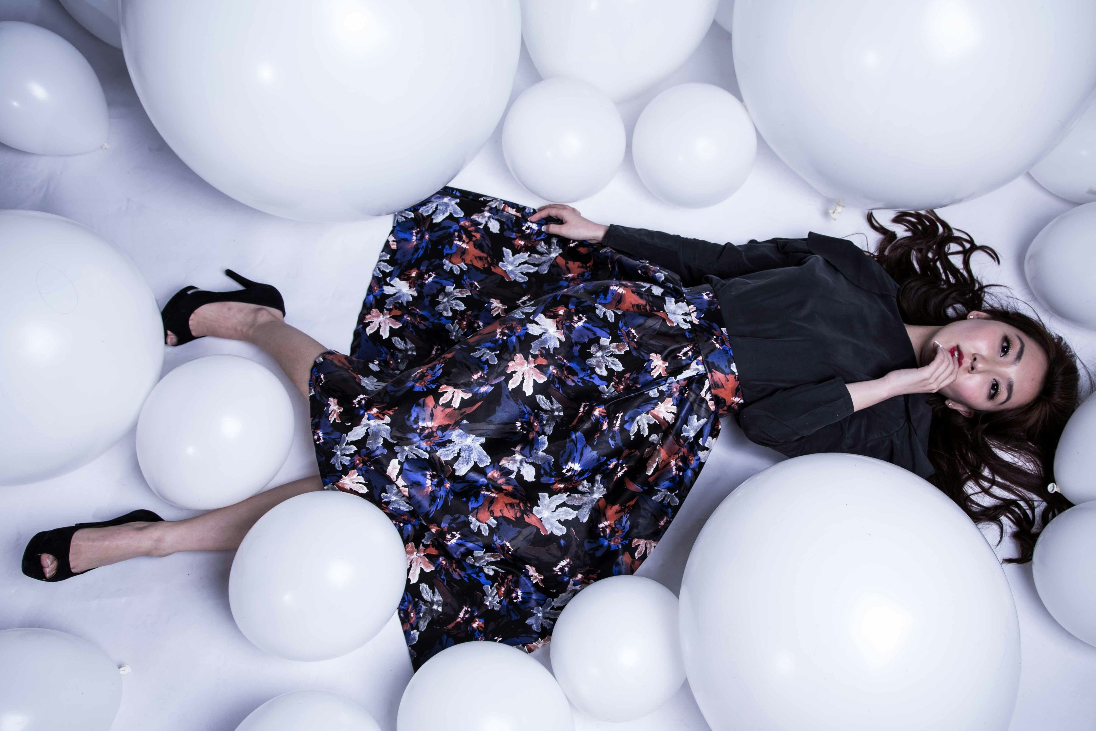 Frau mit buntem Kleid zwischen weißen Kugeln